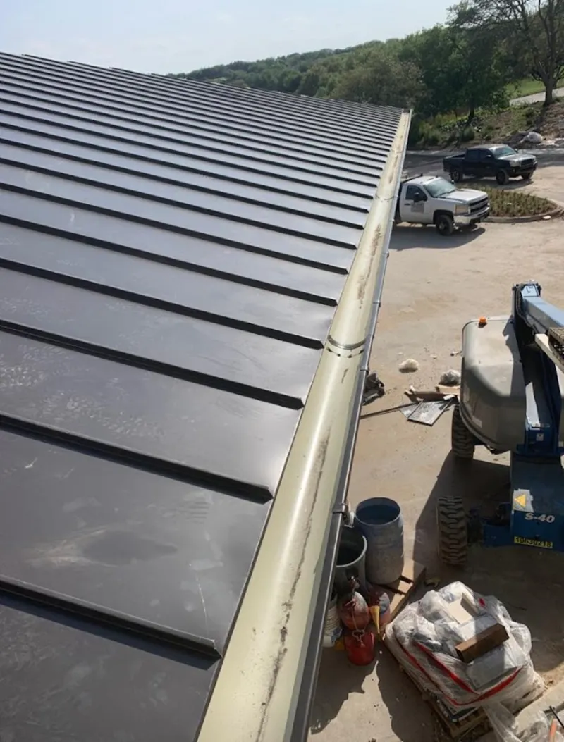 Standing seam panel and gutter detail on a metal roofing jobsite in Monroe